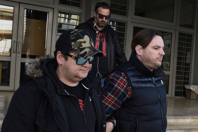 Simon Dutton, 39, right,  is escorted by police officers as he leaves a courthouse at the northern Greek city of Thessaloniki