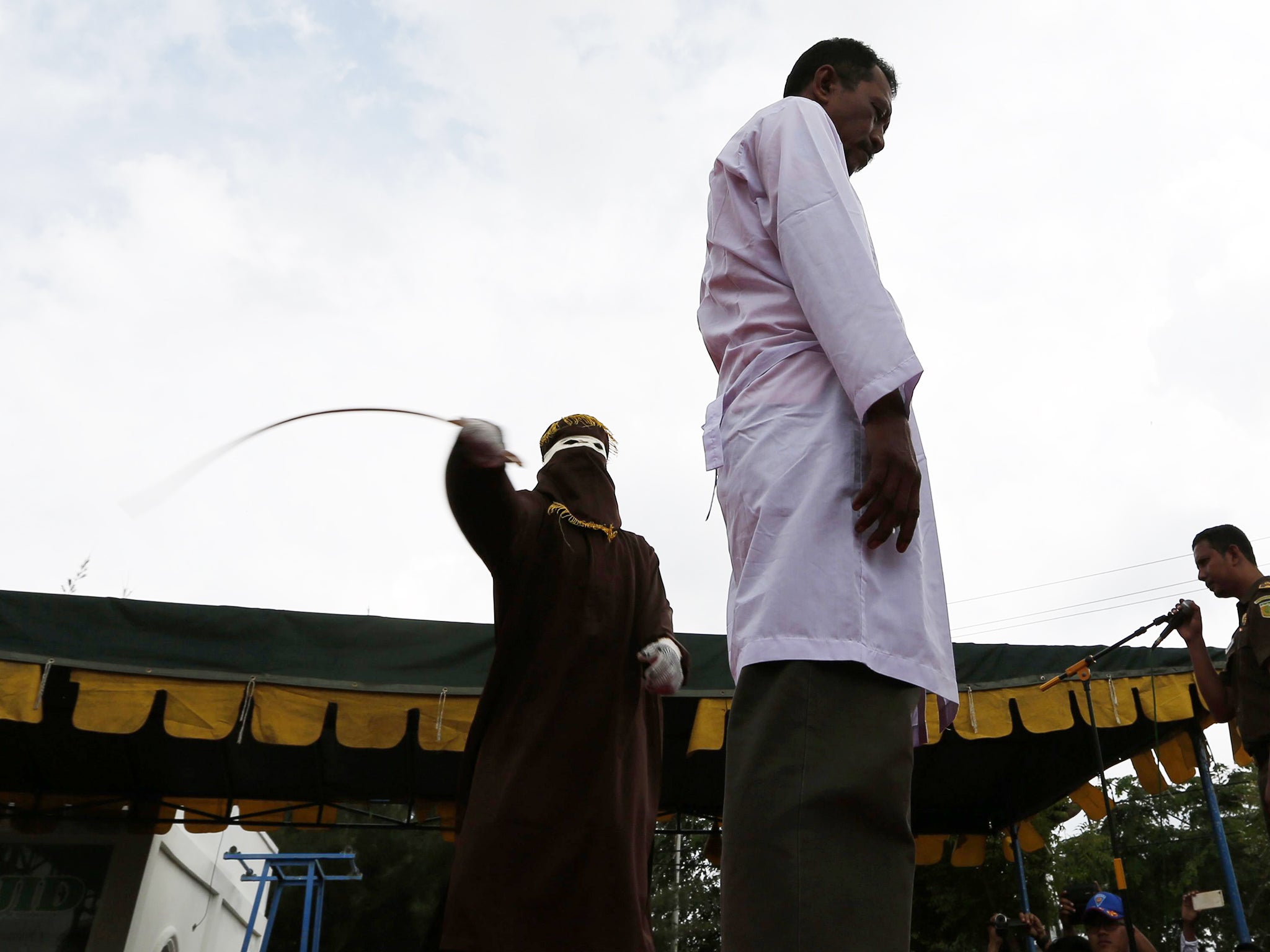 Wahyudi Saputra gets whipped in front of the public for violating the sharia law, in Banda Aceh, Indonesia,