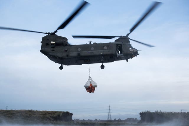 A Royal Air Force Chinook helicopter assisting in repairing a damaged river bank in the flood-hit Lancashire village of Croston