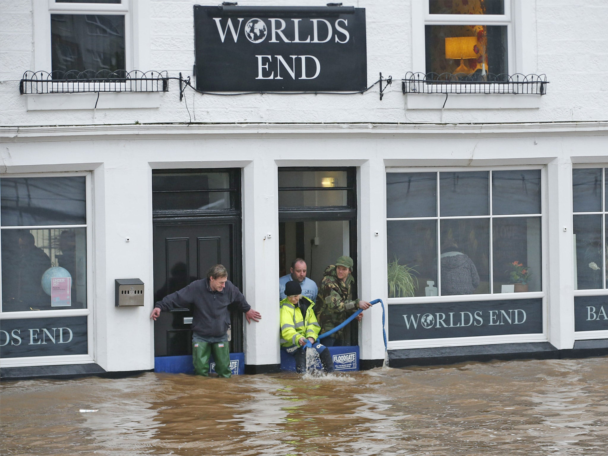 People pump water from the Worlds End pub in Dumfries, Scotland