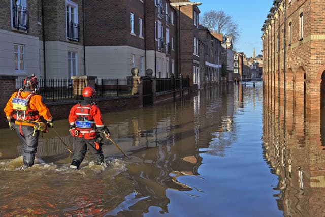 Rescue crews use poles to check the depth of the flood water in Skeldergate in York