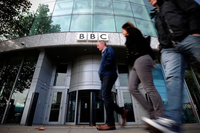 Caption:People walk past one of the entrances to the BBC Television offices in west London, on October 6, 2011