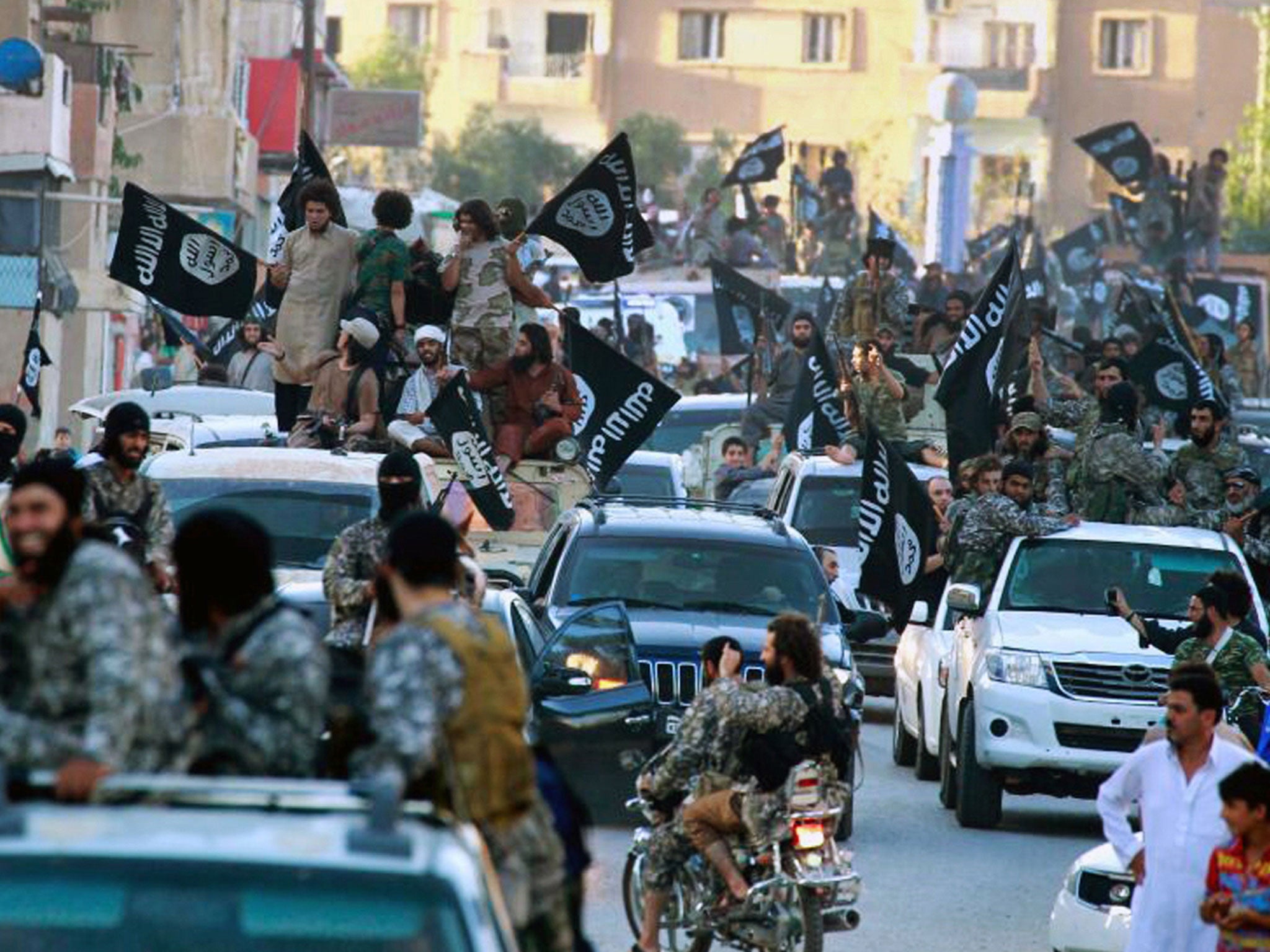 Isis fighters parade in Raqqa, which became the group's de-facto capital in Syria in August 2014.