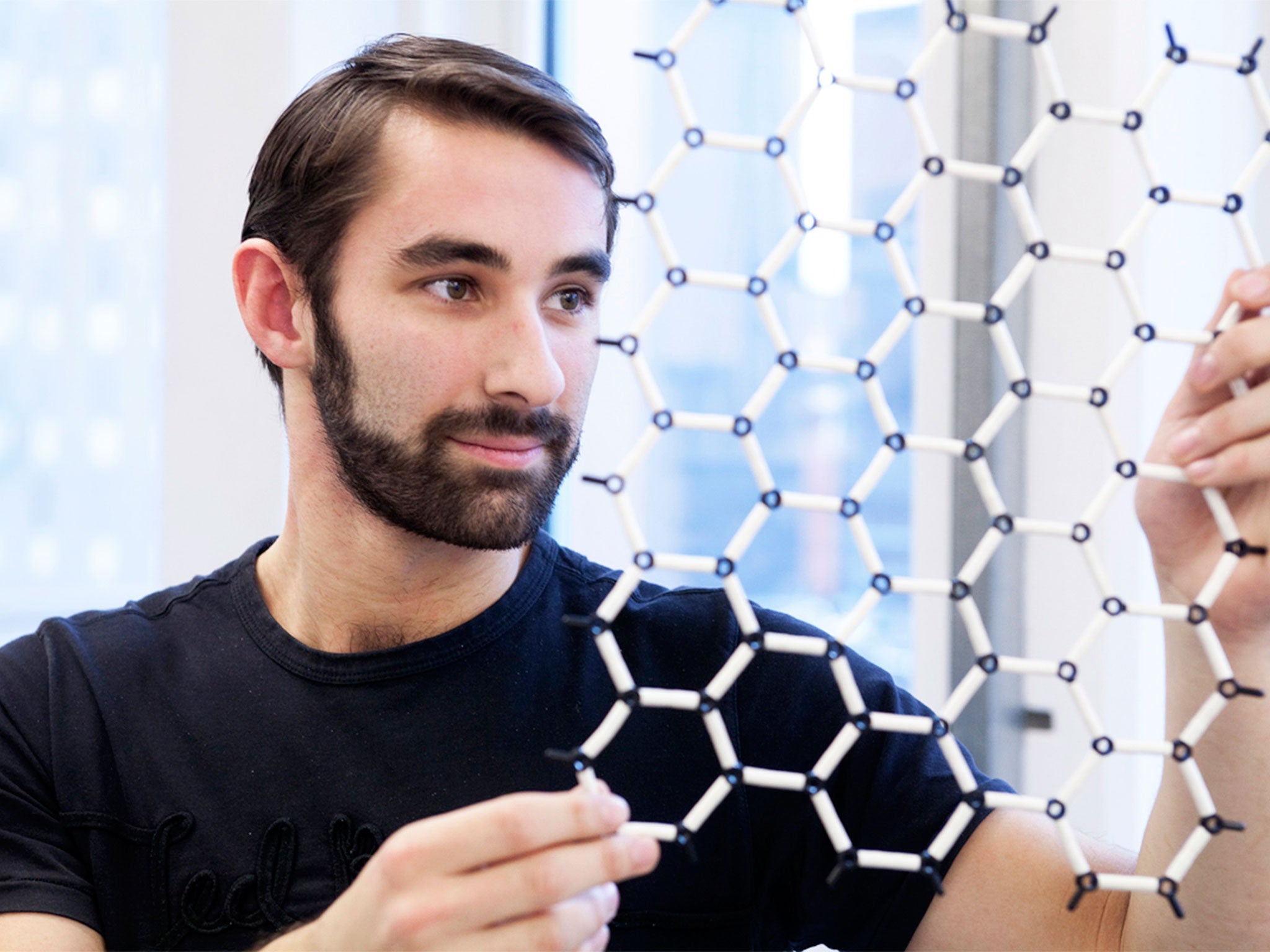 A scientist inspects a model of graphene’s super-fine structure; it can ‘separate items smaller than an atom’