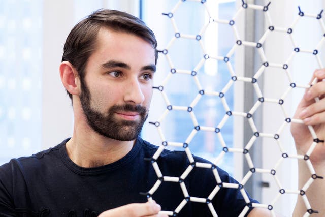 A scientist inspects a model of graphene’s super-fine structure; it can ‘separate items smaller than an atom’