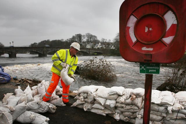 Workers build sand bag walls to try and hold back the river in Newton Stewart in the Scottish Borders following heavy rain from Storm Frank