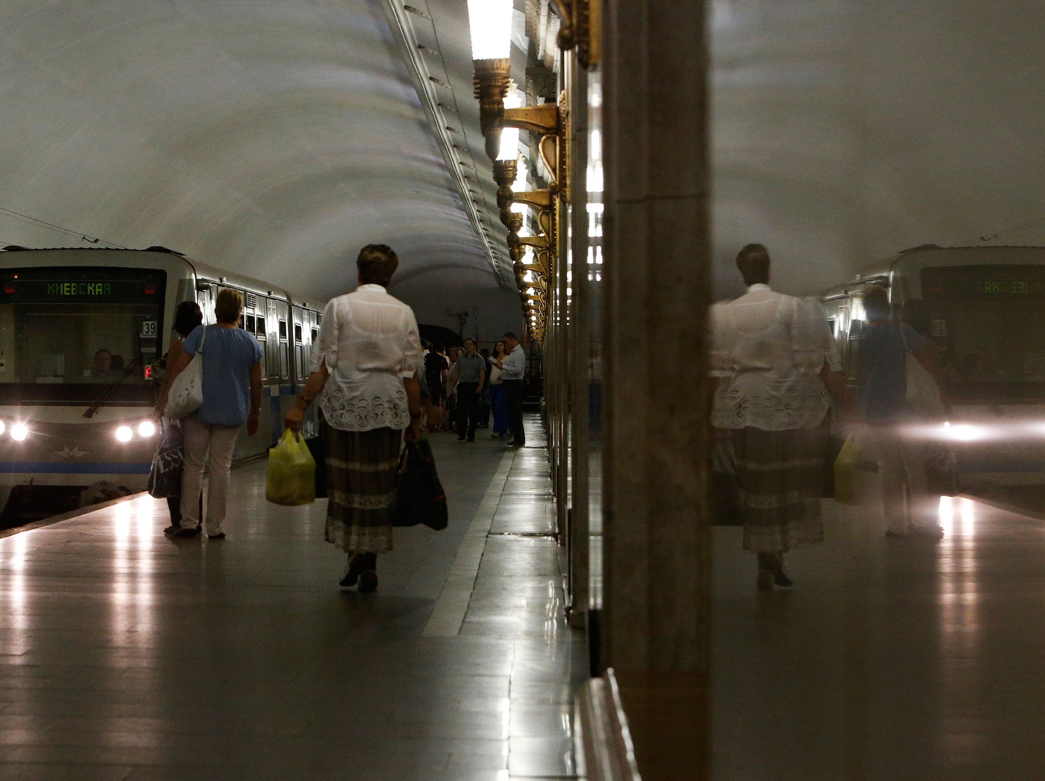 Commuters stand on a platform as a metro train arrives at a station in Moscow July 16, 2014