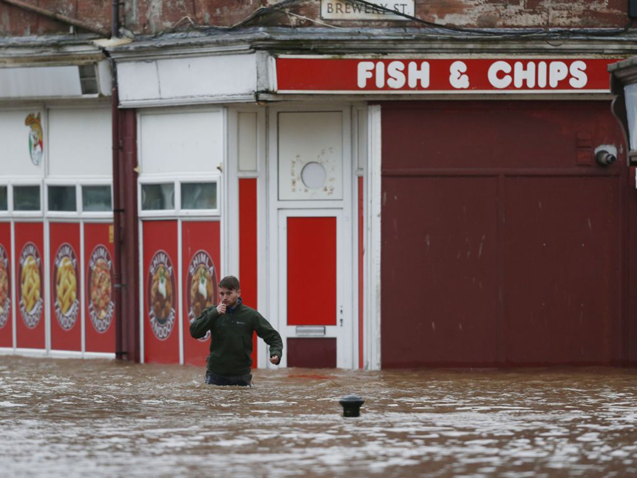 A man wades through the floodwater in Dumfries, Scotland,
