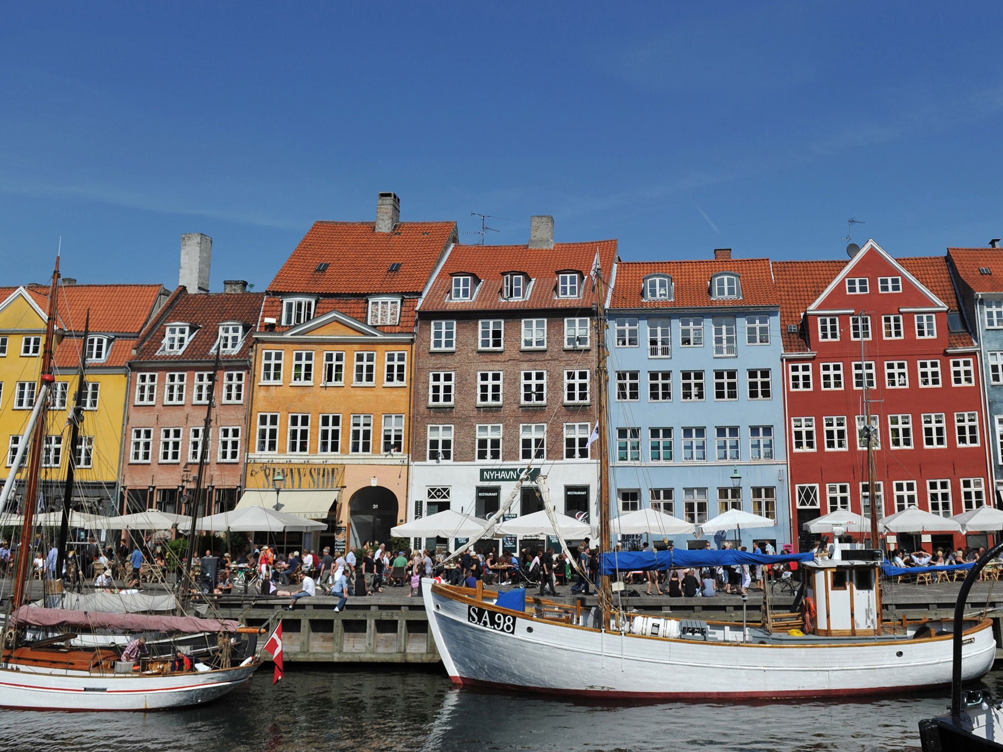 Coulourful houses and boats seen in the Nyhavn district in Copenhagen