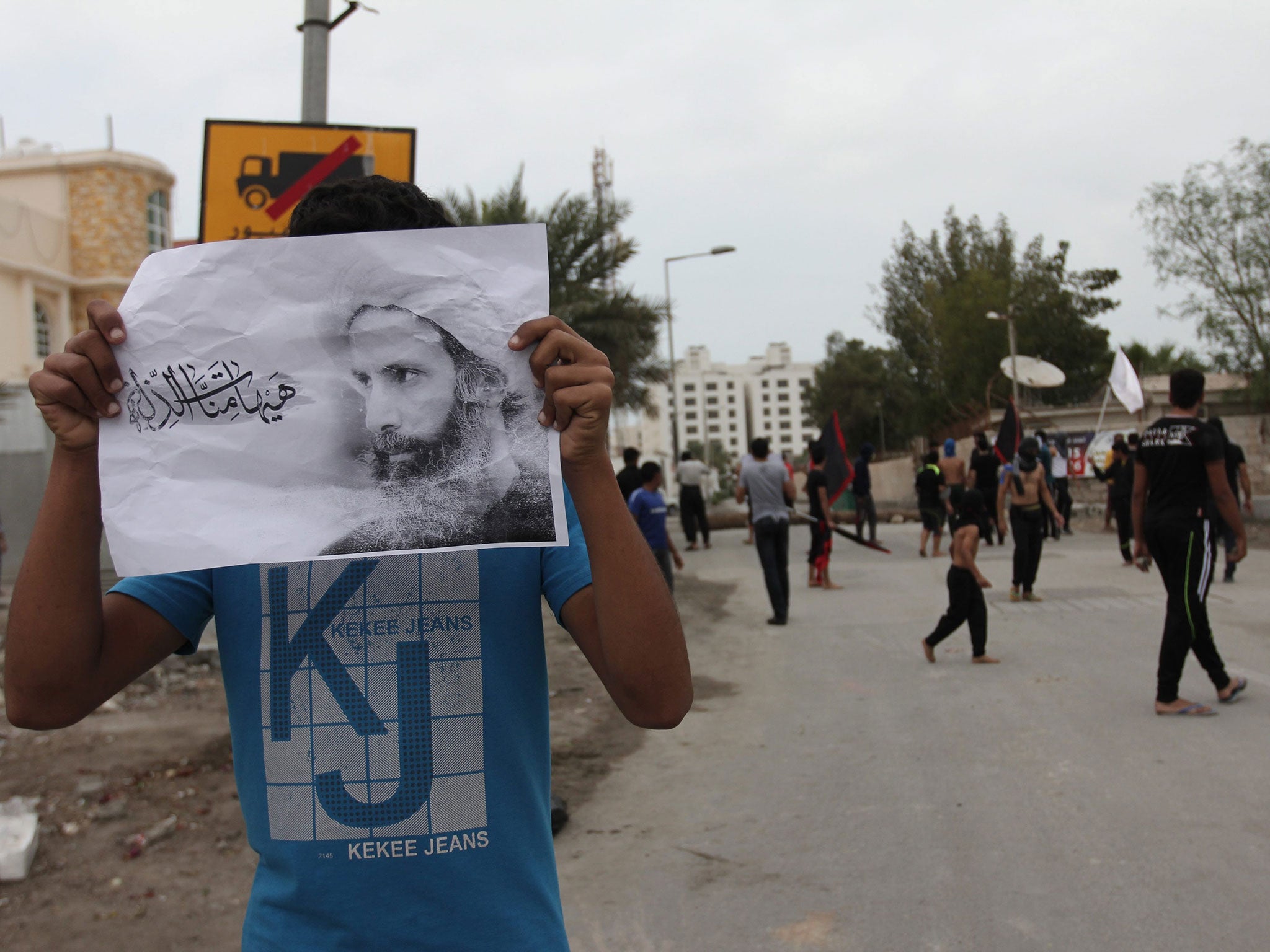 A Bahriani protester holds up a picture of Nimr al-Nimr after his execution
