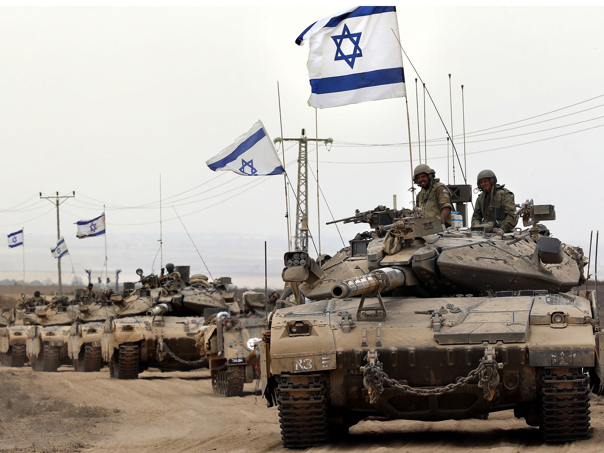 Israeli Merkava tanks drive near the border between Israel and the Gaza Strip as they return from the Hamas-controlled Palestinian coastal enclave on August 5, 2014,