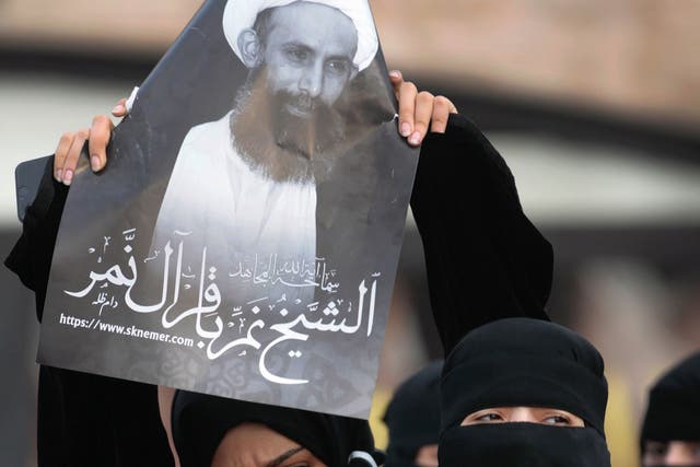 A protester holds a portrait of Sheik Nimr al-Nimr in Qatif