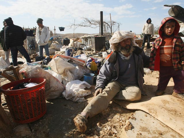Palestinians sit with their belongings after Israeli bulldozers destroyed their home;