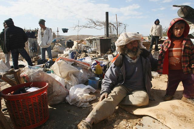 Palestinians sit with their belongings after Israeli bulldozers destroyed their home;