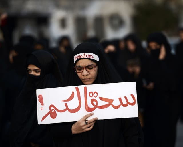 A woman in Bahrain protests against the execution of Nimr al-Nimr with the words 'Damn you'