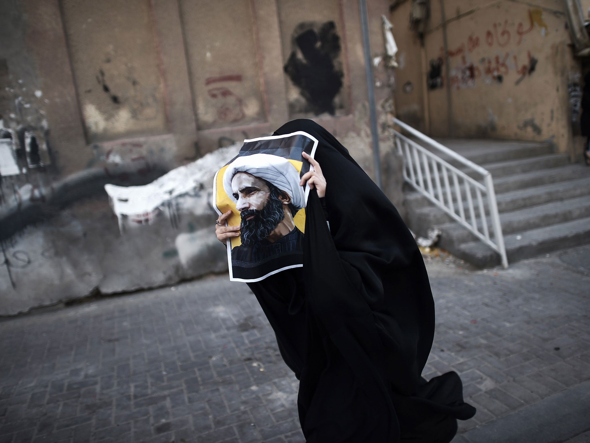 A Bahraini woman bearing a portrait of the executed Shia cleric Nimr al-Nimr during a protest in the capital Manama