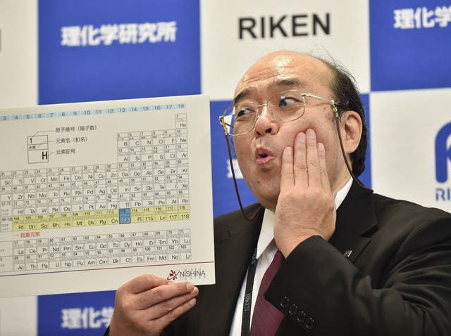 Kosuke Morita, the leader of the Riken team, poses with a board displaying the new atomic element 113 during a press conference in Wako, Saitama prefecture on December 31, 2015