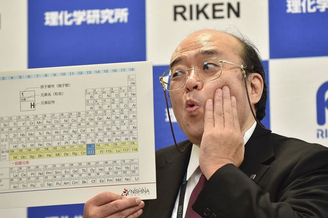 Kosuke Morita, the leader of the Riken team, poses with a board displaying the new atomic element 113 during a press conference in Wako, Saitama prefecture on December 31, 2015