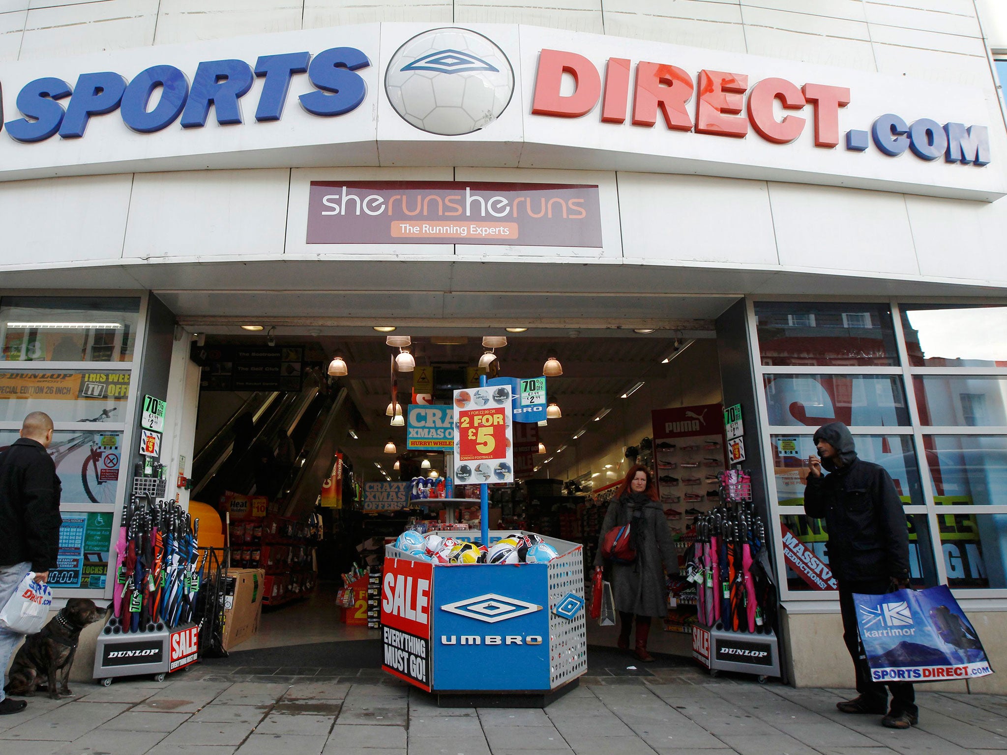 Shoppers wait outside a branch of Sports Direct