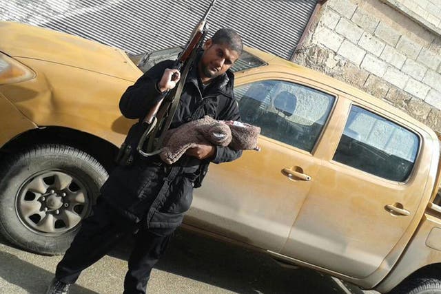 Siddhartha Dhar holds an assault rifle and his infant son soon after his arrival in Syria