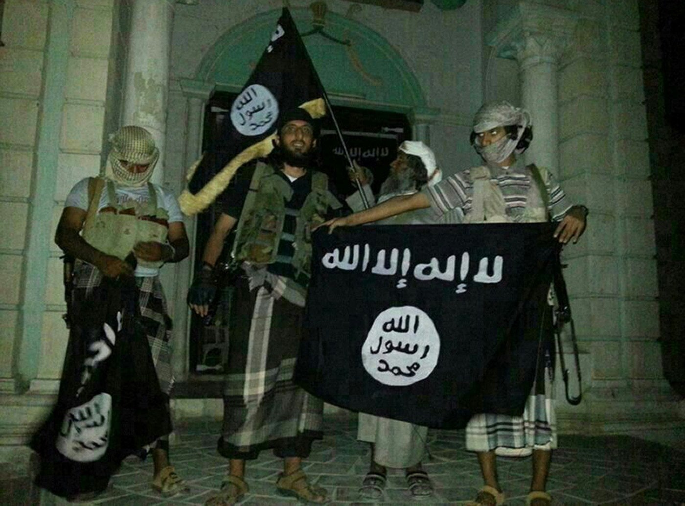 Al-Qaeda militants pose with their flag (the same one used by Isis) in Yemeni city of Seiyun