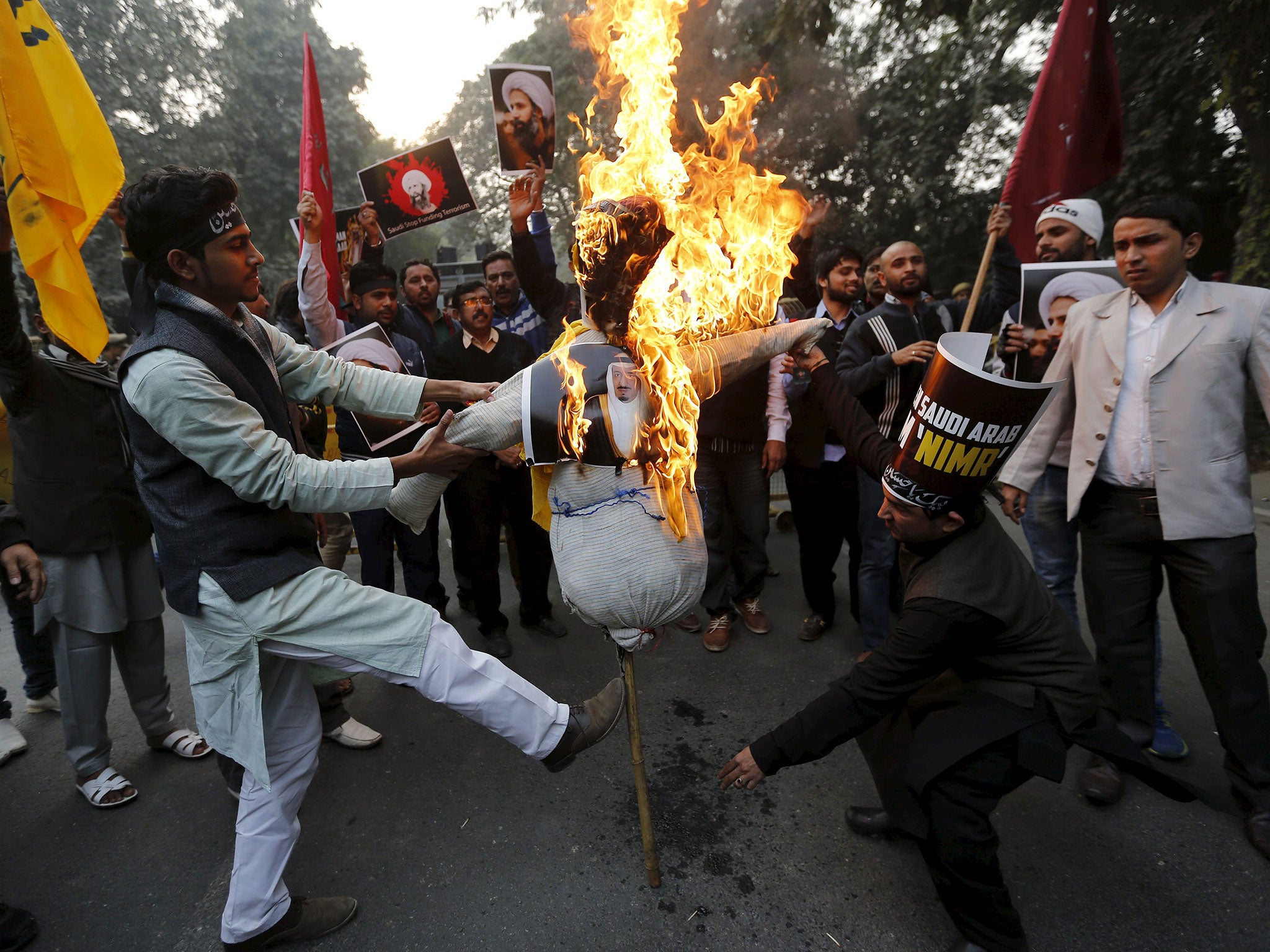 Protesters burn an effigy of Saudi King Salman bin Abdulaziz outside the Saudi embassy in India