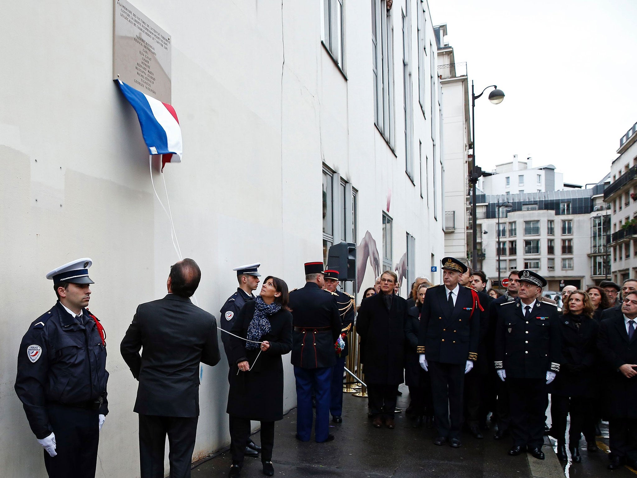 French President Francois Hollande and Paris Mayor Anne Hidalgo unveil a commemorative plaque outside the former offices of French weekly satirical newspaper Charlie Hebdo on January 5, 2016 in Paris