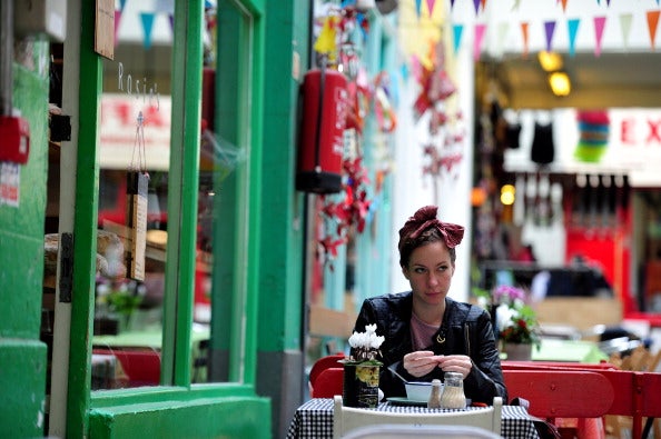 A woman relaxes at a café in Brixton Village, south London. Brixton, the once infamous district, has been transformed by gentrification in recent years