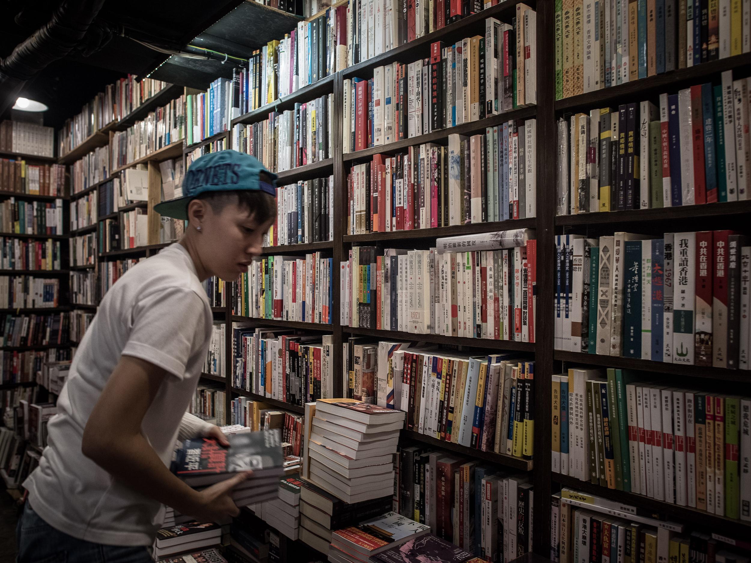 An employee arranges books about China politics in a books store in Causeway Bay district in Hong Kong (Getty)