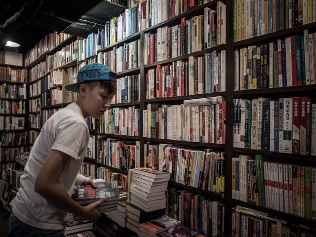 An employee arranges books about China politics in a books store in Causeway Bay district in Hong Kong