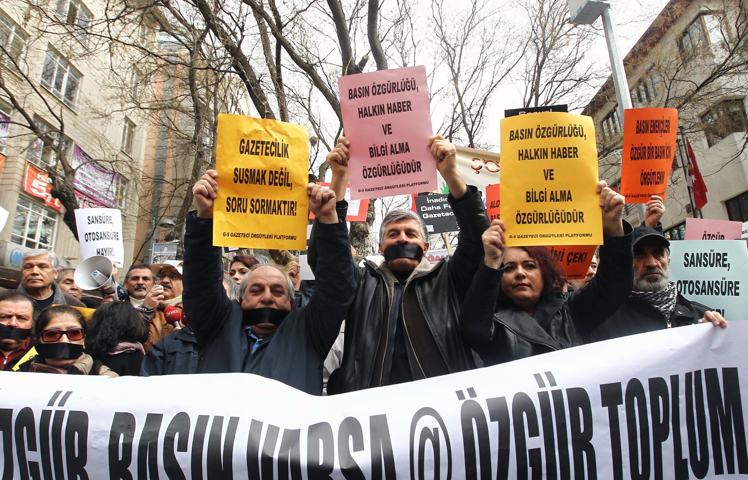 Demonstrators wearing black ribbons over their mouths take part in a protest for press freedom in Ankara in February 2014