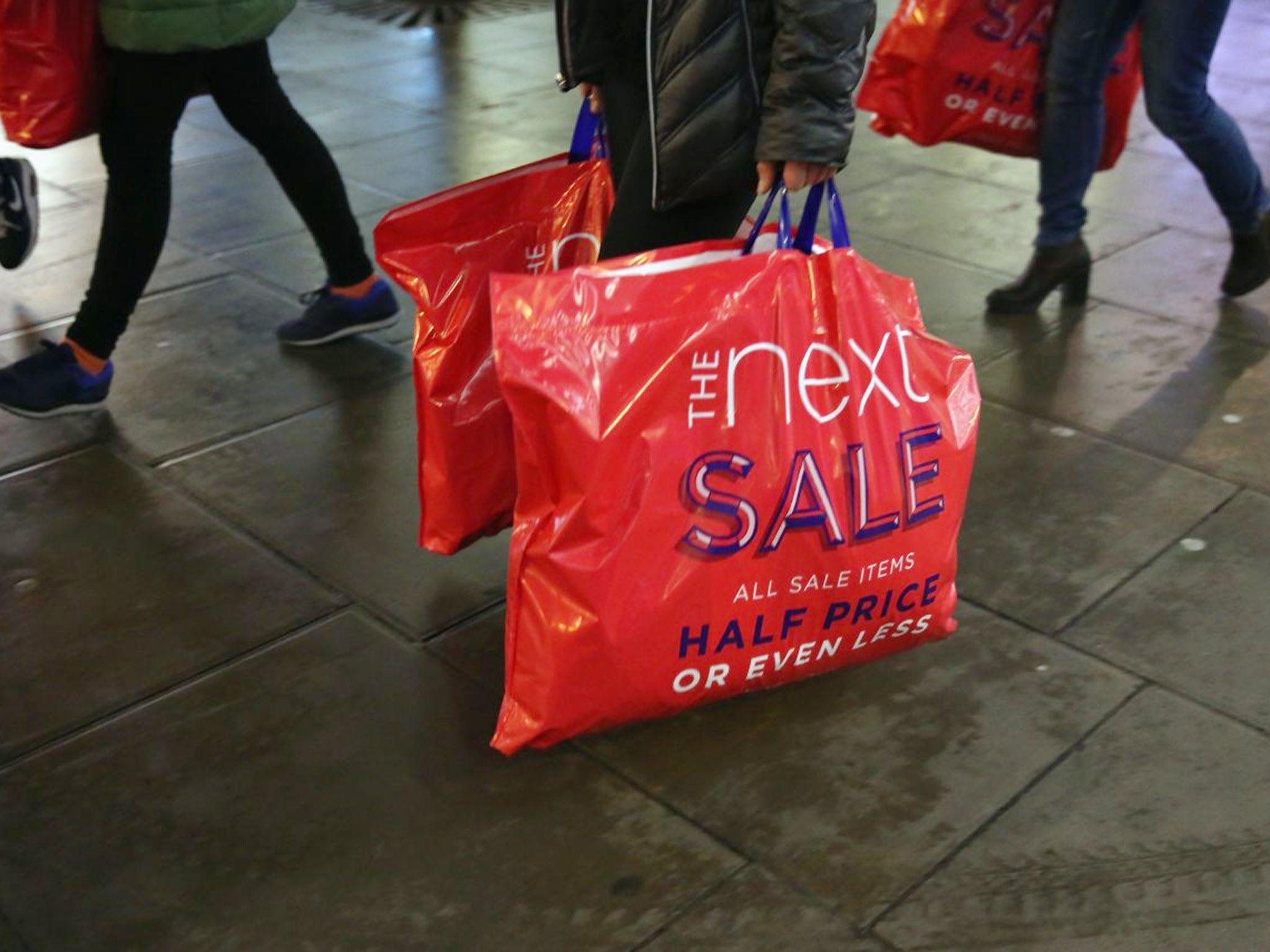 Shoppers carry sales bags from Next in London