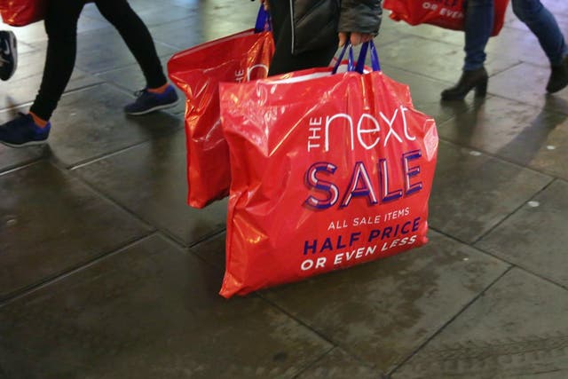 Shoppers carry sales bags from Next in London