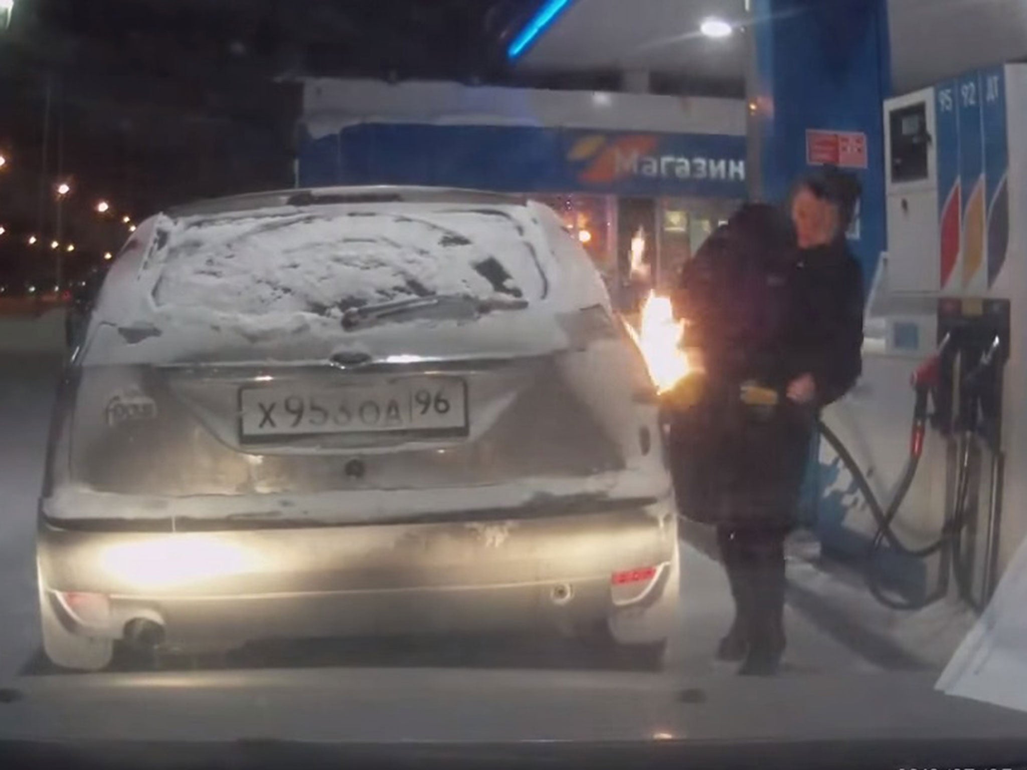 The footage shows the woman recoiling in shock as the petrol ignites