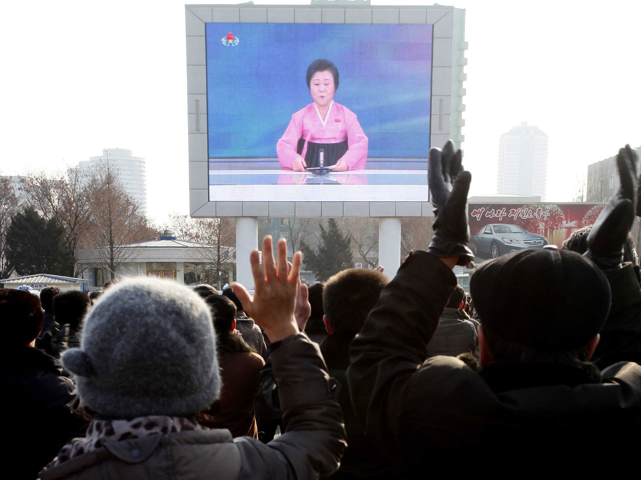 North Koreans watch a news broadcast on a video screen outside Pyongyang Railway Station in Pyongyang, North Korea, Wednesday, Jan. 6, 2016.