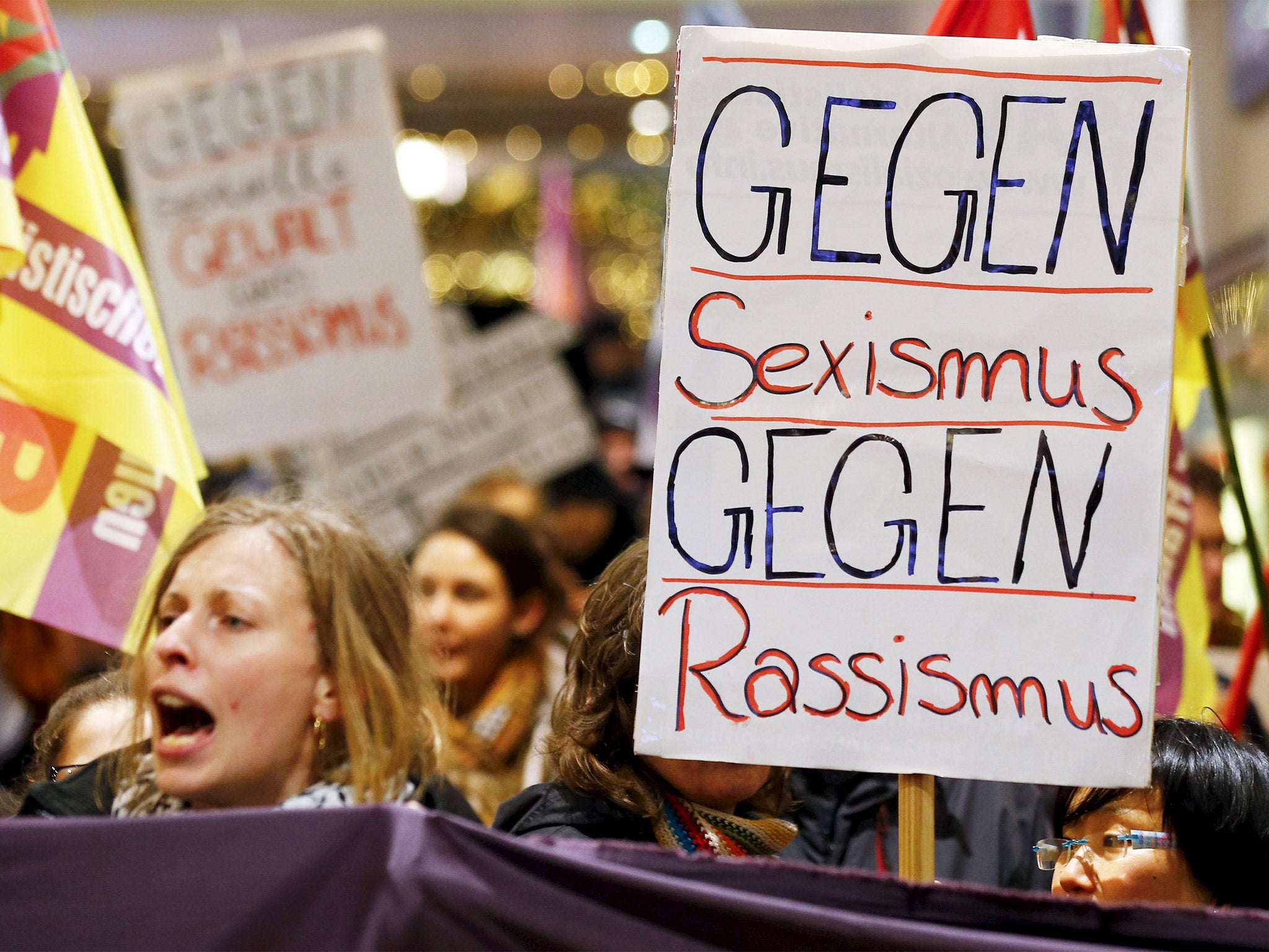 Women march through Cologne holding placards reading ‘Against Sexism, Against Racism’