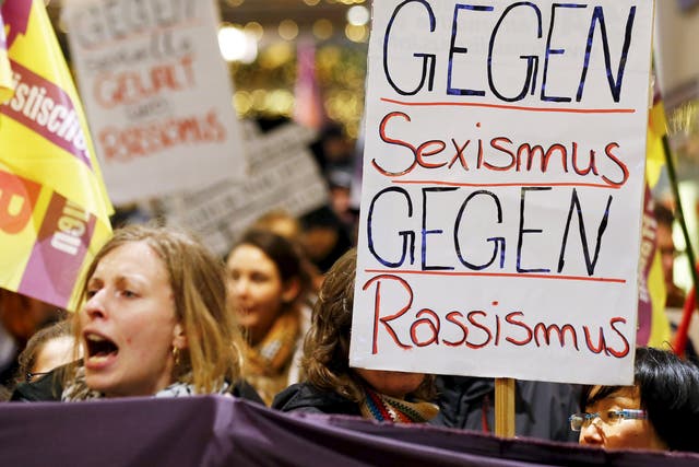 Women march through Cologne holding placards reading ‘Against Sexism, Against Racism’