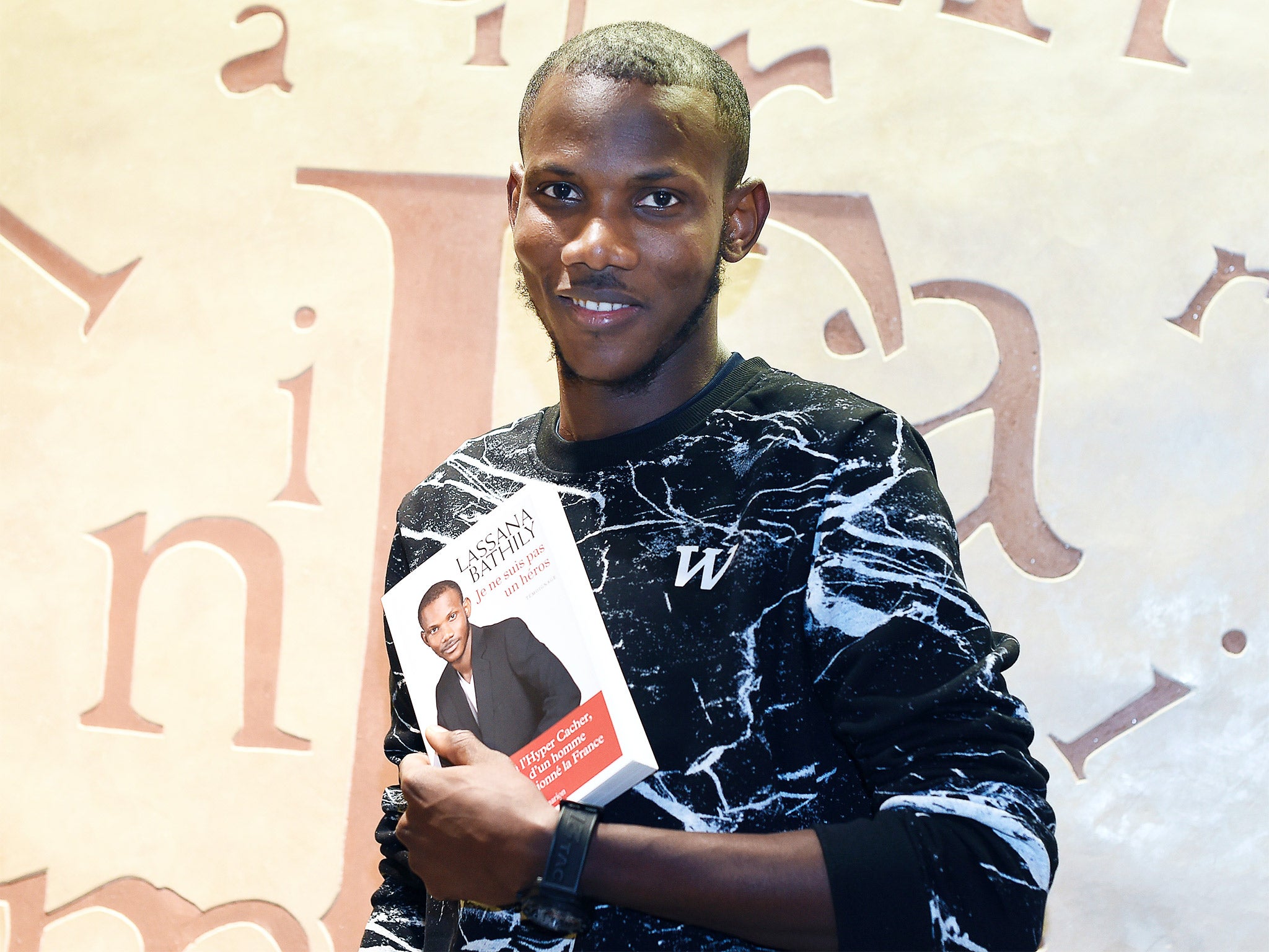 Lassana Bathily with his book ‘Je ne suis pas un heros’ (‘I