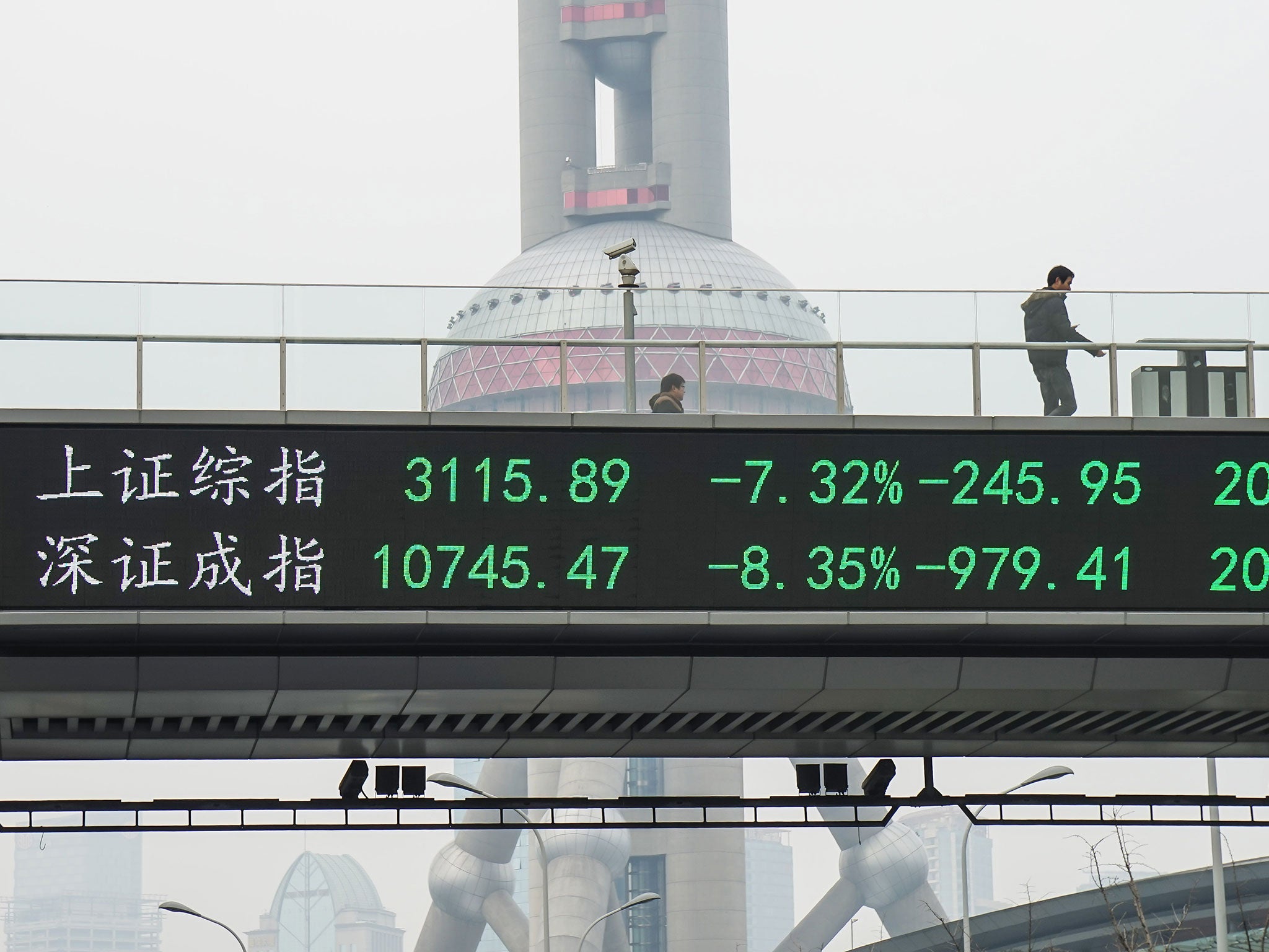A man passes by electric screen showing Chinese shares decreases sharply to a halt point on January 7, 2016 in Shanghai, China. Chinese shares slumped to a halt in half an hour on Thursday which was the second halt in the four trading days of 2016.