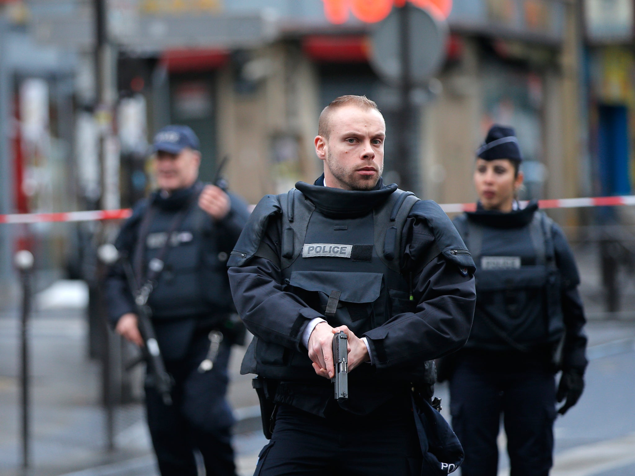 Police officers secure the perimeter near the scene of a fatal shooting which took place at a police station in Paris