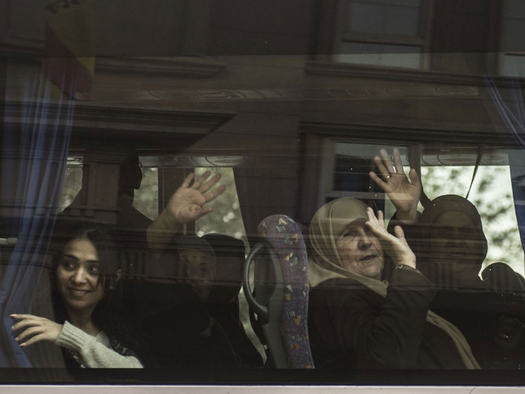 Tourists wave from a bus as they leave the Three Pyramids hotel in Cairo's al-Harm district on January 7, 2016