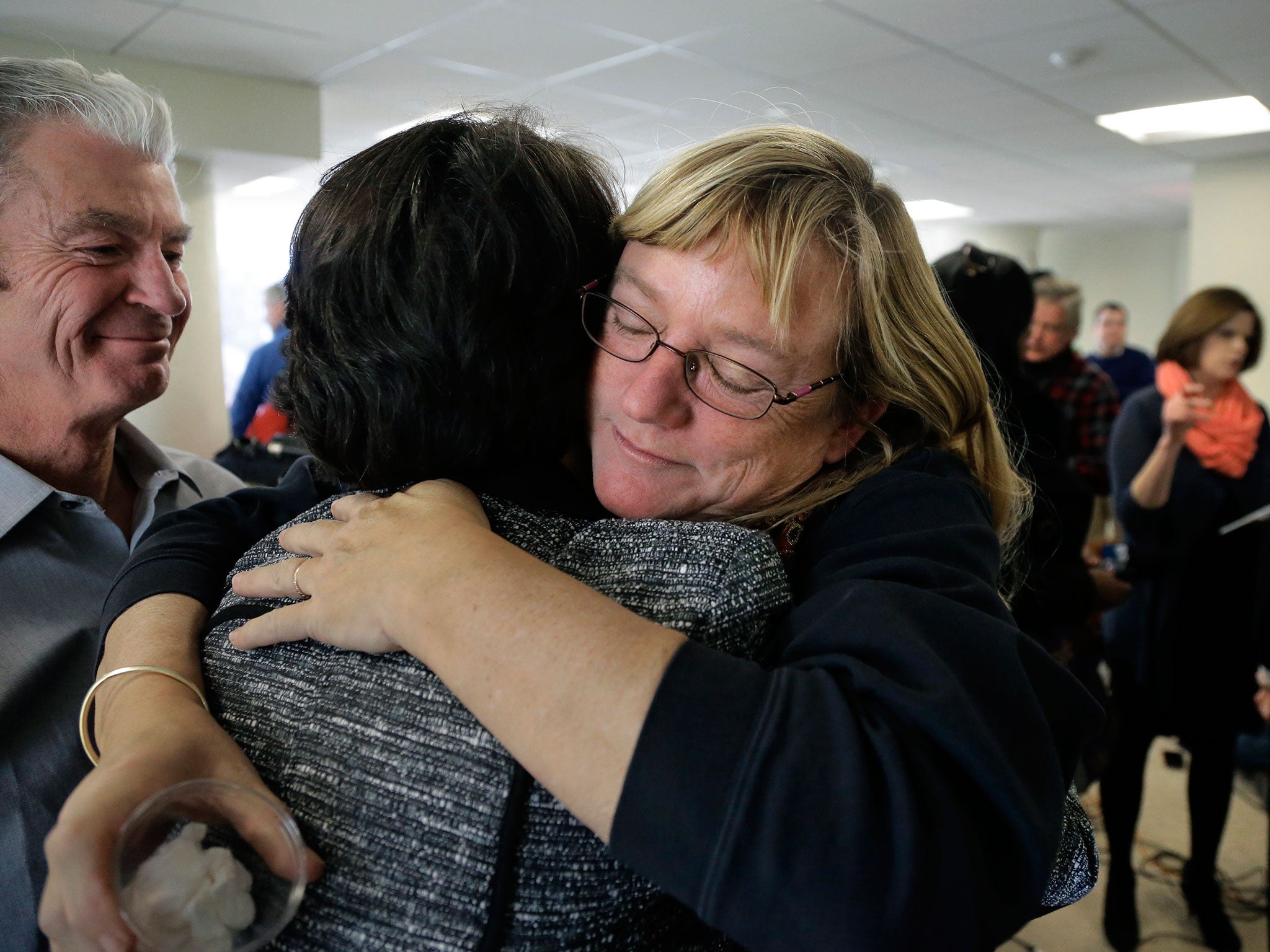 Katie Wales Lovkay, right, who attended St. George’s School from 1977-1980, hugs a former classmate, following a recent news conference about sex abuse at the school