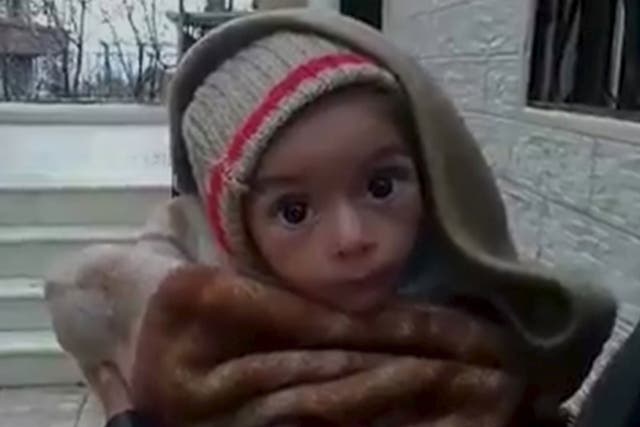 A toddler is held up to the camera in this still image taken from video said to have been shot in Madaya, Syria