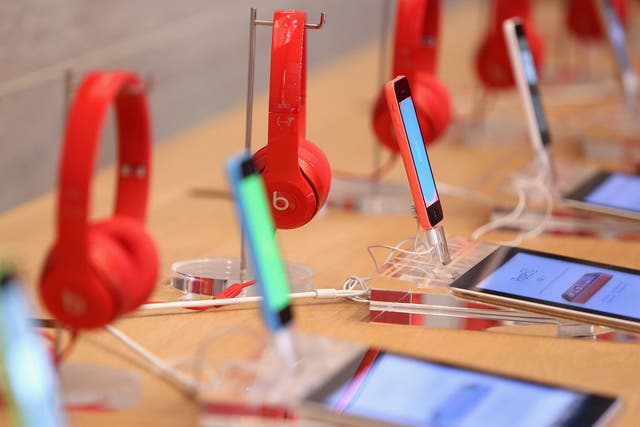 Red Beats by Dre headphones are seen on display behind iPads and iPhones at the Apple Store on December 1, 2014 in Berlin, Germany
