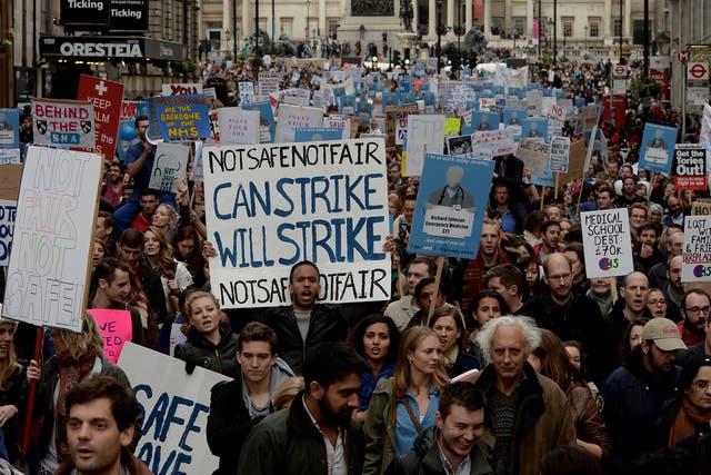 Demonstrators march down Whitehall during the 'Let's Save the NHS' rally and protest march by junior doctors in London
