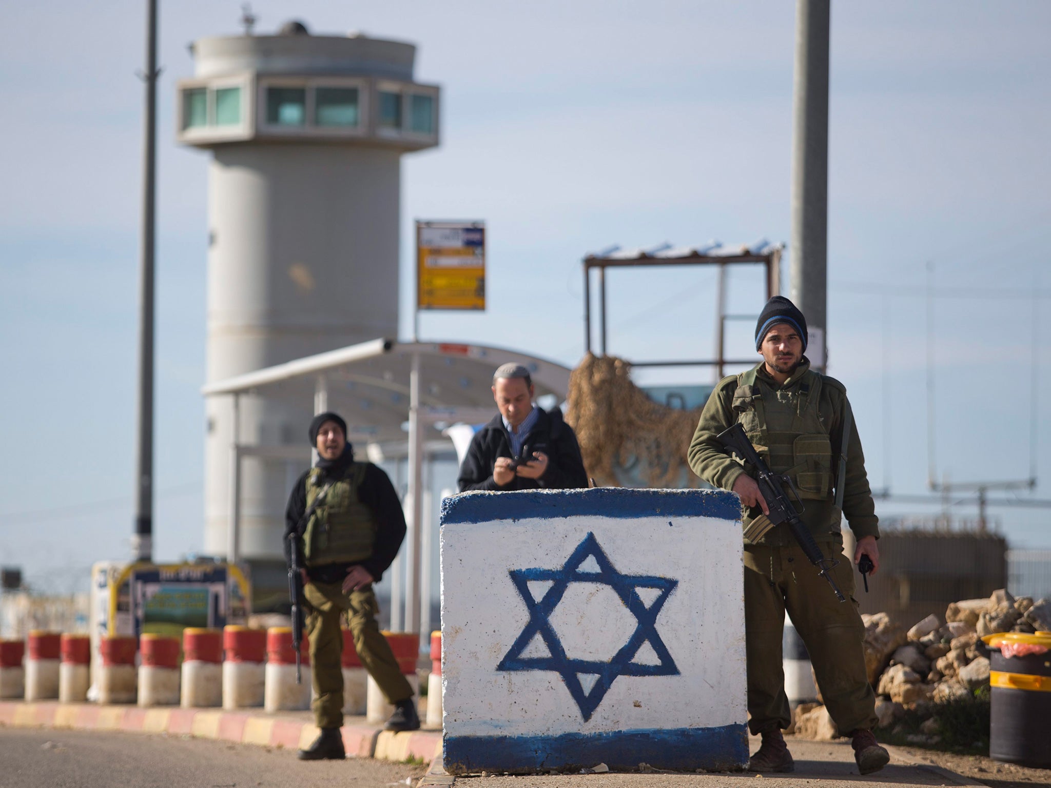 Armed Israeli soldiers stand at a junction near the central bus station in the Gush Etzion settlement. The area has been the focus of clashes.