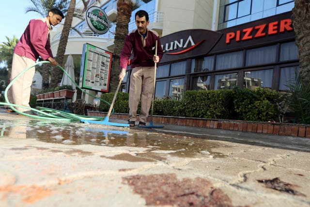 Cleaners try to clean blood stains near the entrance to Bella Vista Hotel in the Red Sea resort of Hurghada, Egypt, January 9, 2016