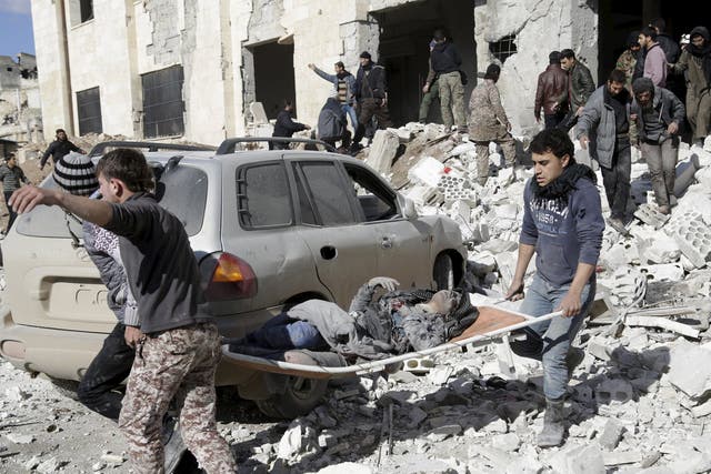 An injured woman is carried away from the wreckage of the prison in Maaret al-Numan