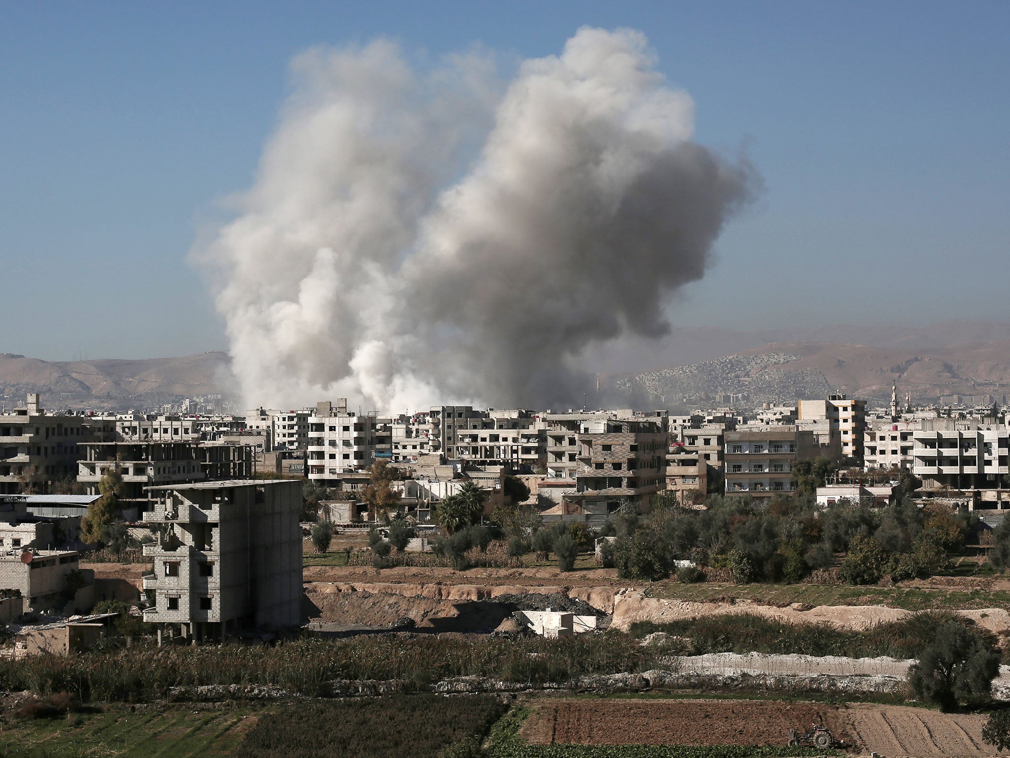 Smoke billows from buildings in the Syrian capital of Damascus