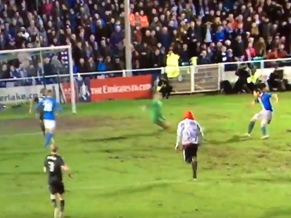 A pitch invader approaches the Bolton goal at Eastleigh